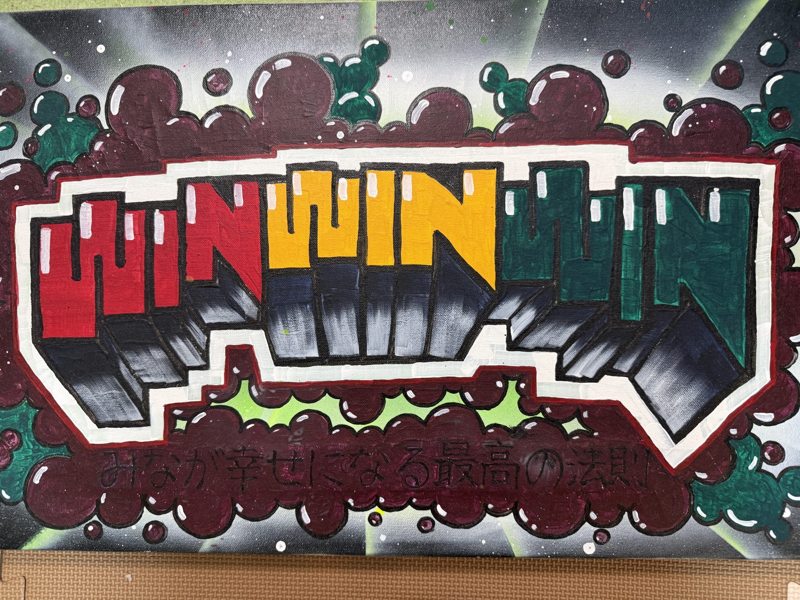 赤・黄・緑でWIN WIN WINと描かれた、上松克也の同級生による絵。